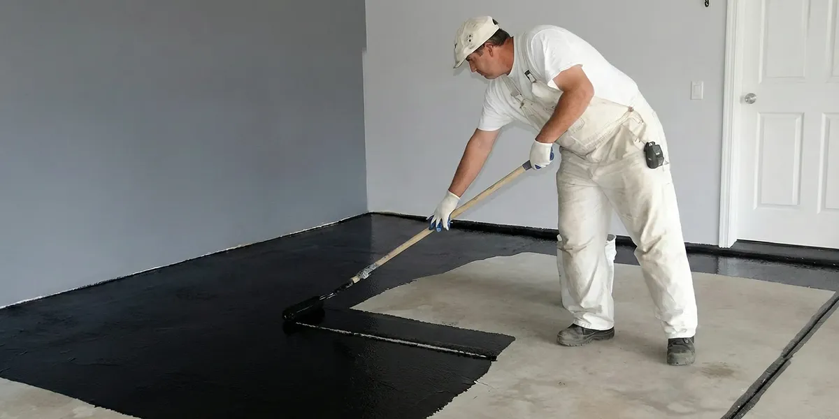 basement waterproofing professional applying waterproof coating to protect a basement floor in San Francisco, CA